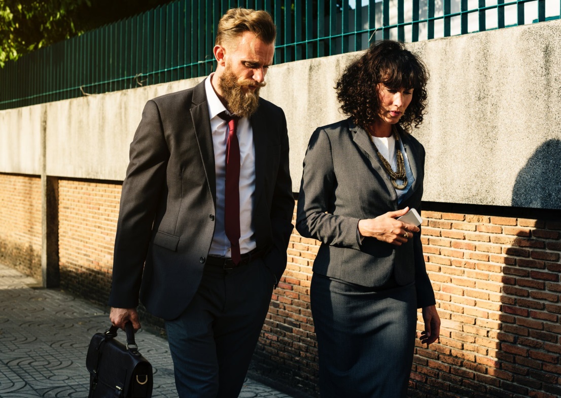 Man and woman walking beside wall